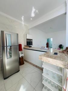 a large kitchen with a stainless steel refrigerator at Casa Perfeita Paracuru in Paracuru
