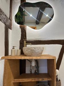 a bathroom vanity with a sink and a mirror at La Cabane in Dambach-la-Ville +6 photos