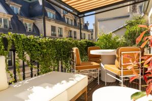 a patio with chairs and a table on a balcony at Hôtel Théorème in Paris
