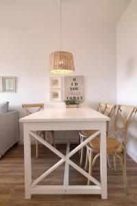 a white dining room table with chairs and a light at Santa Ana 22 by homeprive in El Verger