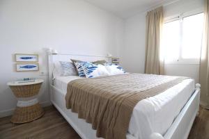 a bedroom with a large white bed with a window at Santa Ana 22 by homeprive in El Verger +6 photos