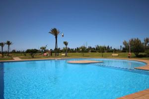 a large blue swimming pool in a park with palm trees at Santa Ana 22 by homeprive in El Verger