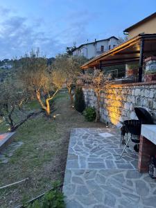 a backyard with a stone wall and a stone patio at Da Ö NOXE in Bracco