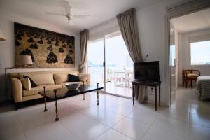 a living room with a couch and a tv at Golden Paradise 75 by homeprive in Jávea