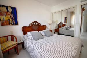 a bedroom with two beds and a chair at Golden Paradise 75 by homeprive in Jávea +12 photos