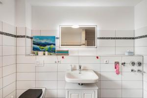 a white bathroom with a sink and a toilet at Ferienwohnung Seeglück in Lauchhammer +20 photos