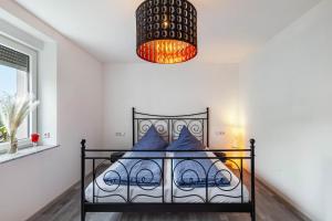 a bedroom with a bed with blue pillows and a chandelier at Ferienwohnung Seeglück in Lauchhammer