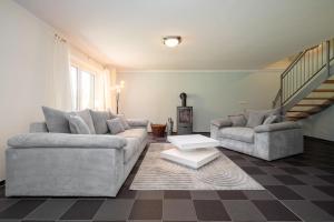 a living room with two couches and a staircase at Ferienhaus Träumerei am Plauer See in Alt Schwerin