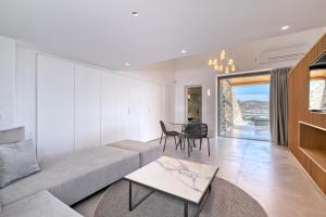 a living room with a couch and a table at Panormos Bay Suites Luxury Resort in Mikonos