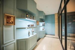 a room with blue walls and shelves with bottles at New Knight Royal Hotel Airport and International Resort in Shanghai