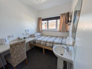 a small room with a bed and a sink at Annie's Accommodation in South Shields