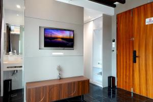 a living room with a tv on the wall at Aura Hotel Purvis in Singapore