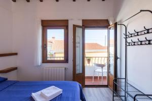 a bedroom with a blue bed and a balcony at El Rincón de Denver 2 in Suances