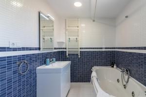 a blue tiled bathroom with a toilet and a tub at El Rincón de Denver 2 in Suances +17 photos