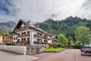 a white building with balconies and a mountain at Casa Morsich in Predazzo
