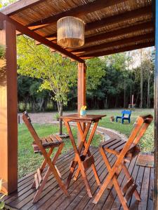 a wooden table and two chairs on a wooden deck at Cabana de teto de vidro in Santa Cruz do Sul