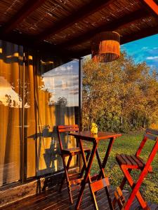 a picnic table and two chairs on a deck at Cabana de teto de vidro in Santa Cruz do Sul
