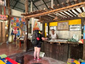 a woman with a backpack standing at a counter at Chill Out Bar and Bungalows in Tonsai Beach