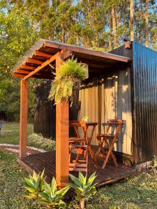 a wooden deck with a table and chairs in front of a shed at Cabana de teto de vidro in Santa Cruz do Sul +43 photos