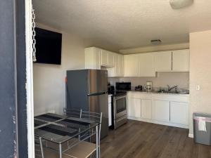 a kitchen with a stainless steel refrigerator and white cabinets at The Lake Huron Resort in Oscoda +55 photos