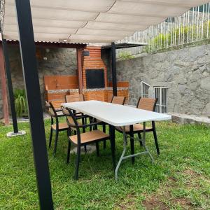 a white table and chairs under an umbrella at La casa del cuadro in Lima