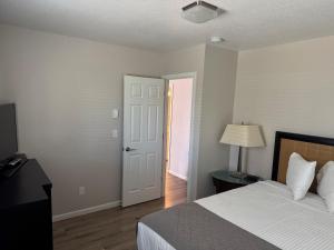 a bedroom with a bed and a door with a lamp at The Lake Huron Resort in Oscoda