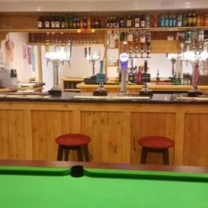 a bar with two stools in front of a pool table at Y Llew Coch Tregaron in Tregaron