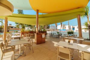 a restaurant with tables and chairs under a large umbrella at Stamatia Hotel in Ayia Napa
