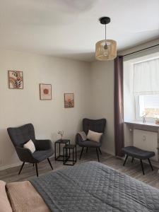 a bedroom with two chairs and a bed and a window at Dianas Ferienwohnung 1 in Feldberg
