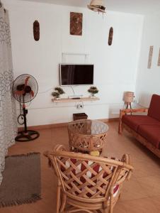 a living room with a couch and a tv at Appart Chris Mindelo in Mindelo