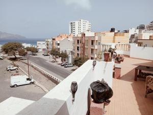 a person standing on a balcony looking at a city at Appart Chris Mindelo in Mindelo