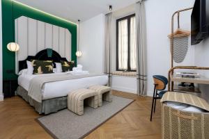 a bedroom with a large bed with a green headboard at CSE MS Museo Select in Seville