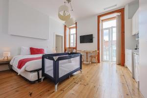 a bedroom with a bed and a tv in it at Casa de São Bento by PURUS in Coimbra