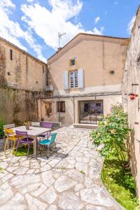 a patio with a table and chairs and a building at Maison Françoise in Monpazier