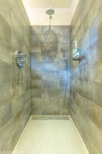 a bathroom with a shower with a shower head at Maison Françoise in Monpazier +28 photos