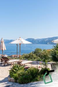 a beach with chairs and umbrellas and the ocean at Hotiday Cala Gonone in Cala Gonone