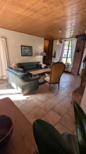 a living room with a couch and a table at Manoir du Taillis in Heugon