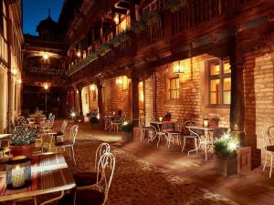 a patio with tables and chairs in a building at Cour du Corbeau Hotel Strasbourg - MGallery Collection in Strasbourg