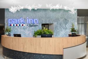 a park inn recharge lobby with potted plants at Park Inn by Radisson Sarvar Resort & Spa - All Inclusive in Sárvár