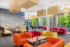 a lobby with colorful chairs and tables at Park Inn by Radisson Sarvar Resort & Spa - All Inclusive in Sárvár