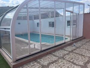a glass house with a swimming pool inside at Casa rural El Terreno in Teruel
