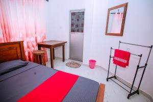 a bedroom with a bed and a table and a mirror at LHK Dream Resort Matara in Palatuwa