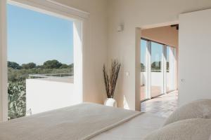 a bedroom with a bed and a large window at SON MARTORELL by BookMenorcaVillas Unique country house in Mahón +40 photos