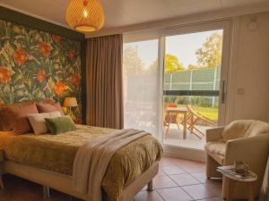 a bedroom with a bed and a sliding glass door at B&B The Protea in Zonnebeke