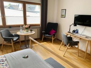 a living room with chairs and a table and a tv at Ahrweiler Seelchen in Bad Neuenahr-Ahrweiler