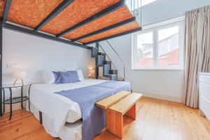 a bedroom with a large bed and a staircase at Casa de São Bento by PURUS in Coimbra