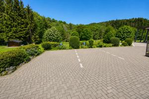 a brick parking lot with a bench in a park at Appartment Haus Müller in Kelberg