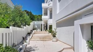 a walkway of a white building with a white fence at Villa Perla Baska in Baška