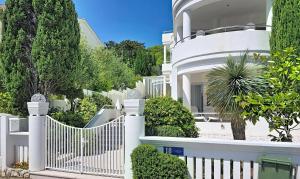 a white fence in front of a white house at Villa Perla Baska in Baška