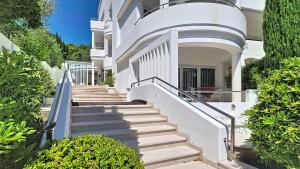 a white house with stairs in front of it at Villa Perla Baska in Baška